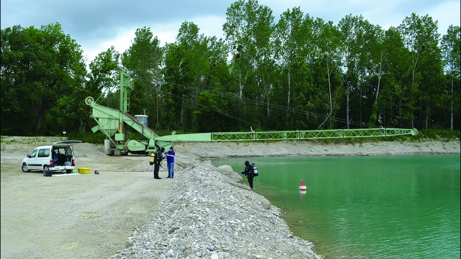 Археологические водолазы осматривают гравийный карьер, где были обнаружены 500 древних железных брусков.